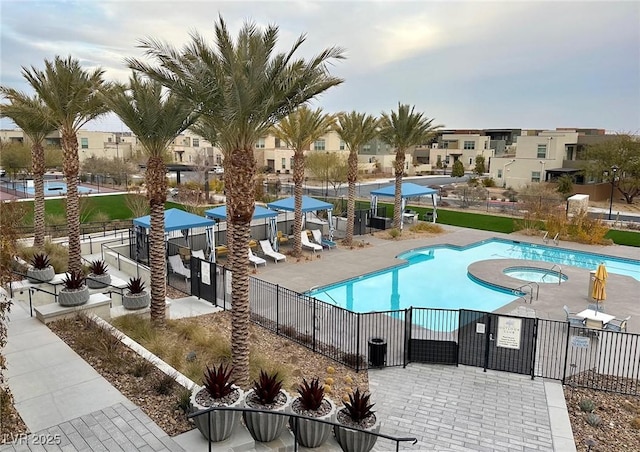 view of swimming pool featuring a hot tub and a patio