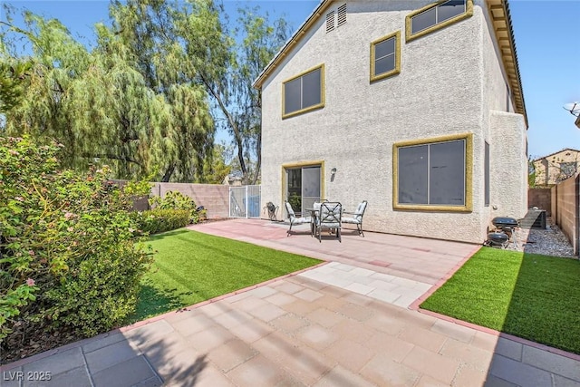 back of property featuring a patio area and a lawn