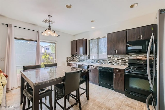 kitchen featuring tasteful backsplash, dark brown cabinets, pendant lighting, and black appliances