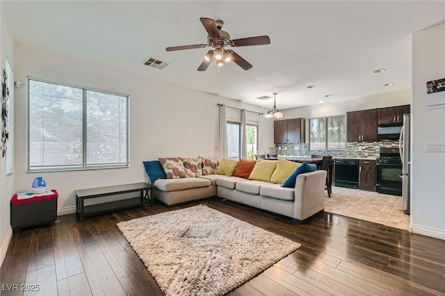 living room featuring ceiling fan and dark hardwood / wood-style flooring