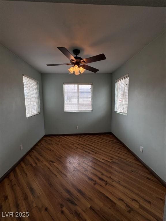 unfurnished room featuring dark wood-type flooring and ceiling fan