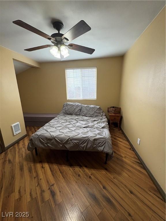 bedroom featuring ceiling fan, dark hardwood / wood-style floors, and vaulted ceiling