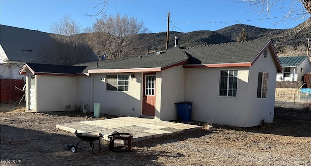 back of property featuring a mountain view and a patio