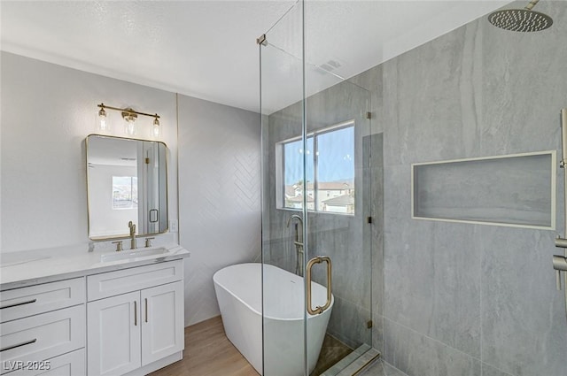 bathroom with hardwood / wood-style flooring, vanity, shower with separate bathtub, and a wealth of natural light