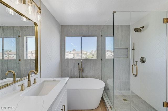 bathroom with vanity and shower with separate bathtub