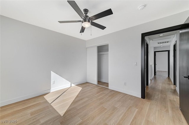 unfurnished bedroom featuring ceiling fan, a closet, and light hardwood / wood-style flooring