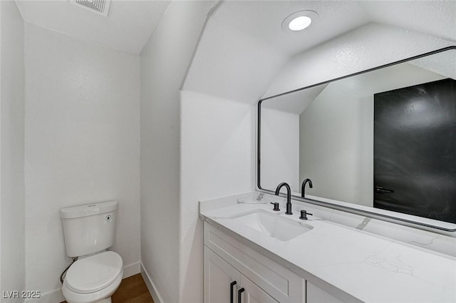 bathroom with vanity, toilet, and hardwood / wood-style floors