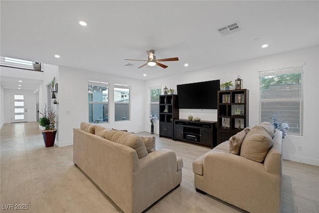 living room featuring a wealth of natural light and ceiling fan