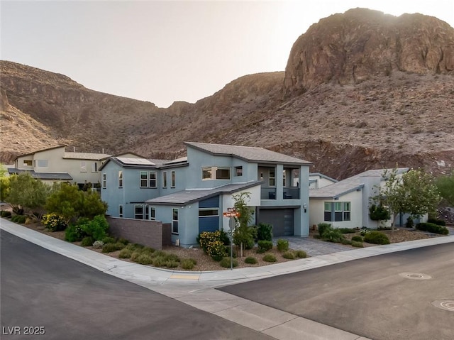 view of front facade with a garage and a mountain view