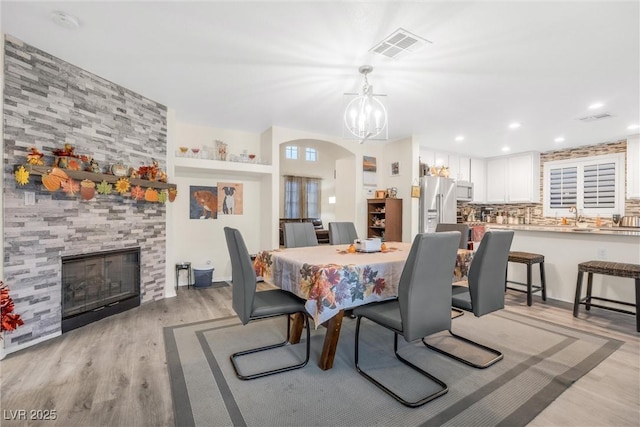 dining room with a large fireplace and light hardwood / wood-style flooring