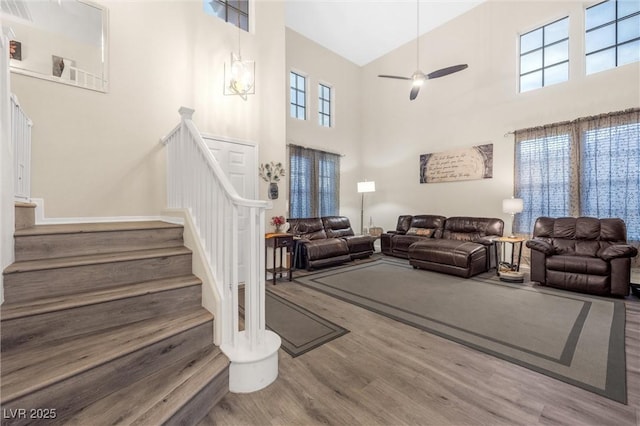 living room featuring a high ceiling, hardwood / wood-style floors, and ceiling fan