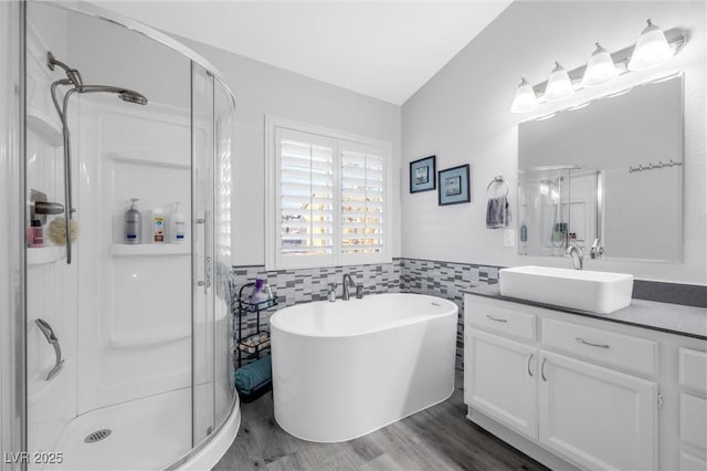 bathroom with vanity, wood-type flooring, independent shower and bath, and tile walls