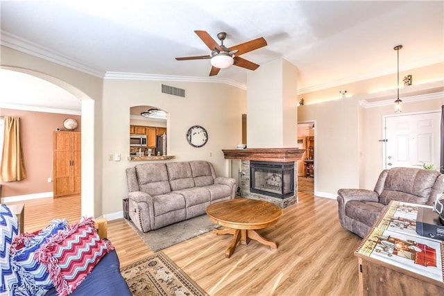 living room featuring crown molding, a multi sided fireplace, ceiling fan, and light hardwood / wood-style flooring