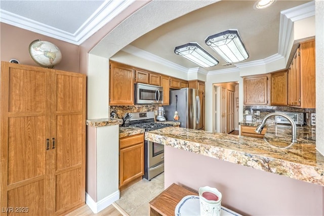 kitchen with light tile patterned floors, crown molding, stainless steel appliances, and decorative backsplash