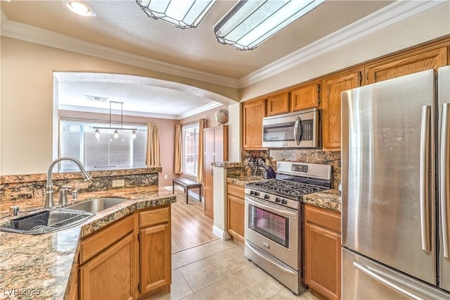 kitchen with sink, appliances with stainless steel finishes, hanging light fixtures, tasteful backsplash, and ornamental molding