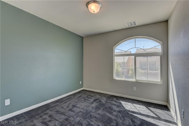 spare room featuring dark carpet