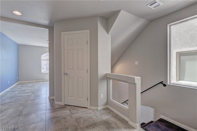 staircase featuring tile patterned flooring and a textured ceiling