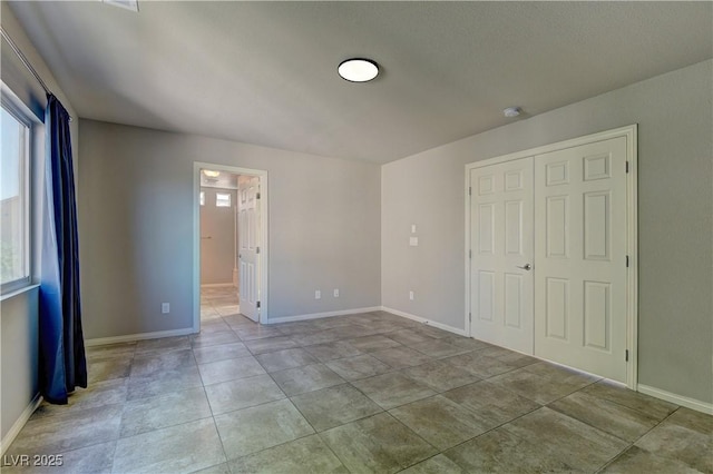 unfurnished bedroom with connected bathroom and light tile patterned floors