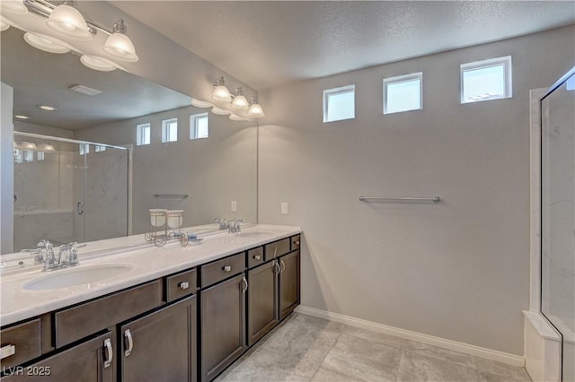 bathroom with vanity, a shower with shower door, and a healthy amount of sunlight