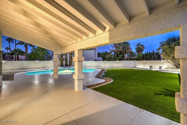 patio terrace at dusk with a fenced in pool and a yard