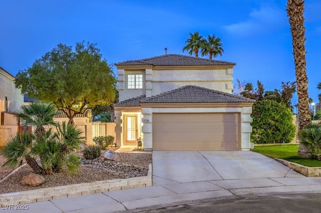 view of front of home featuring a garage, fence, a tile roof, concrete driveway, and stucco siding