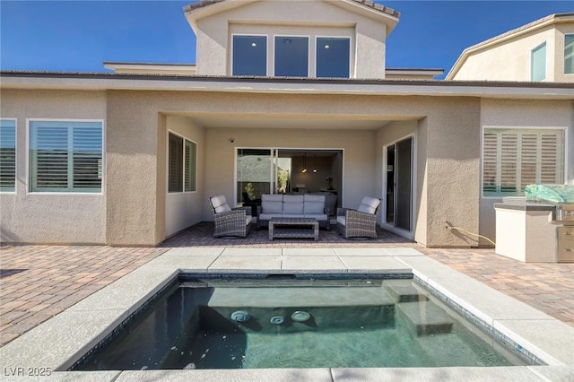 back of house with an outdoor hangout area, a pool with hot tub, and a patio