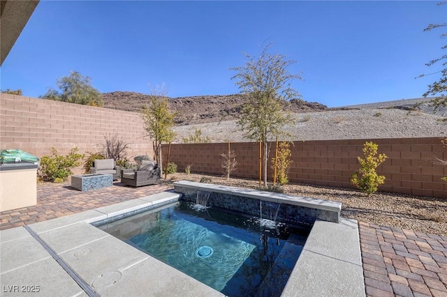 view of swimming pool featuring a patio, pool water feature, and an outdoor hot tub