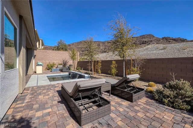 view of patio with a mountain view, a fenced in pool, and a grill