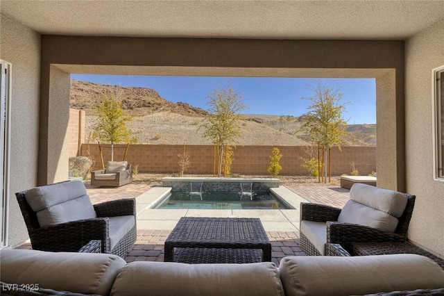 view of patio / terrace with an outdoor living space, a mountain view, and a fenced in pool