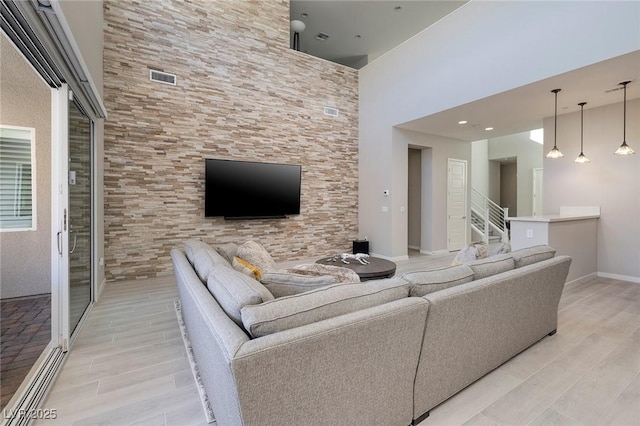 living room featuring light hardwood / wood-style floors and a high ceiling