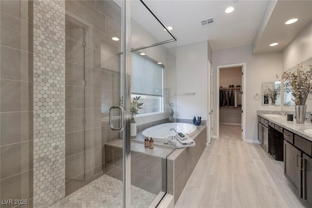 bathroom featuring vanity, hardwood / wood-style flooring, and shower with separate bathtub