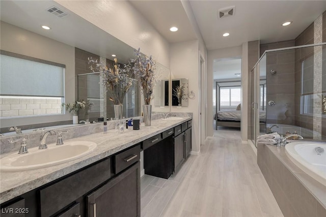 bathroom with vanity and independent shower and bath