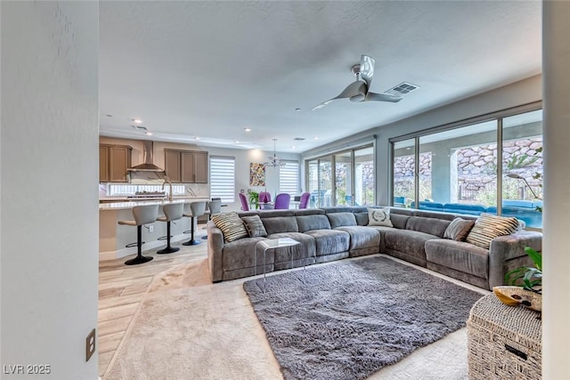 living room with ceiling fan with notable chandelier