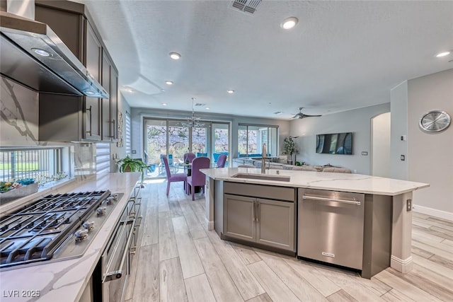 kitchen with pendant lighting, sink, gray cabinetry, stainless steel dishwasher, and gas stovetop