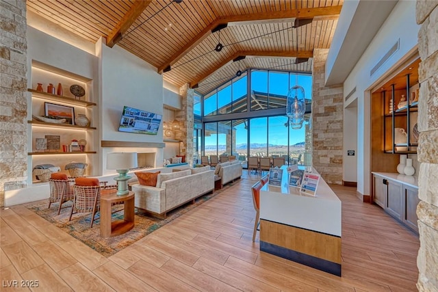 living room featuring beam ceiling, light hardwood / wood-style floors, built in features, and wooden ceiling