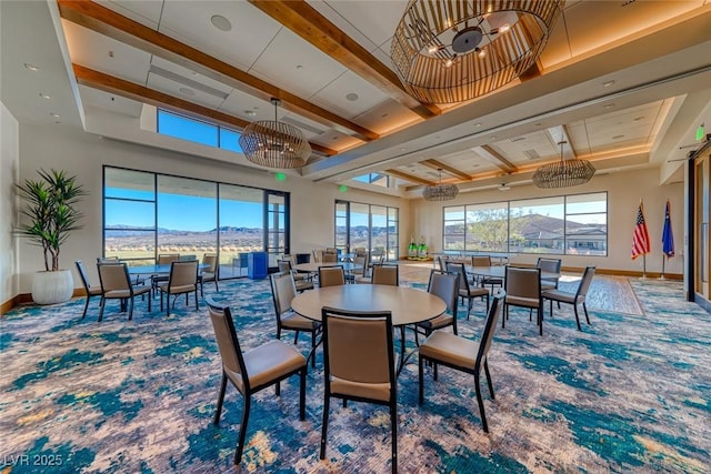 carpeted dining area with beamed ceiling, a mountain view, and a high ceiling