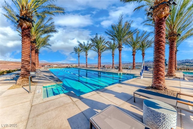 view of swimming pool featuring a mountain view and a patio