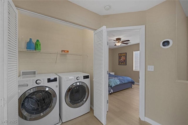 laundry area featuring ceiling fan, washer and clothes dryer, and light hardwood / wood-style floors