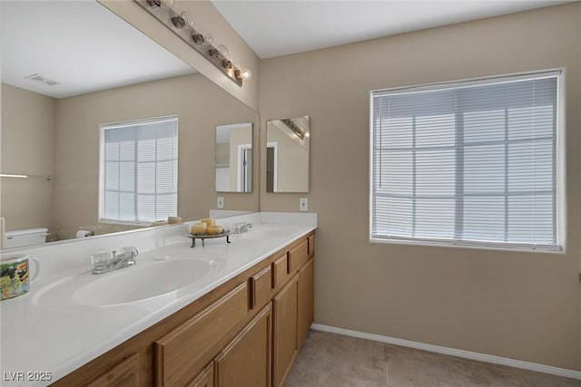 bathroom featuring tile patterned flooring, vanity, a wealth of natural light, and toilet