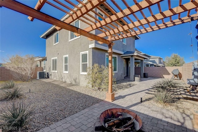 exterior space featuring an outdoor fire pit, a pergola, and central air condition unit