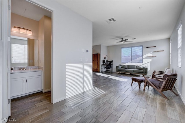 living room featuring ceiling fan and sink