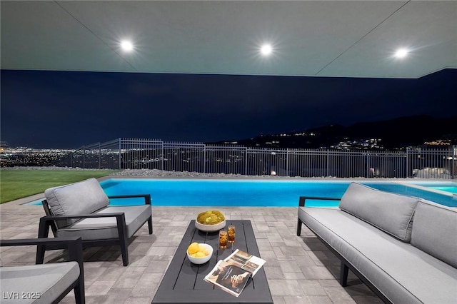 pool at twilight with a patio and an outdoor hangout area