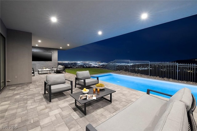 pool at night featuring an outdoor living space and a patio area