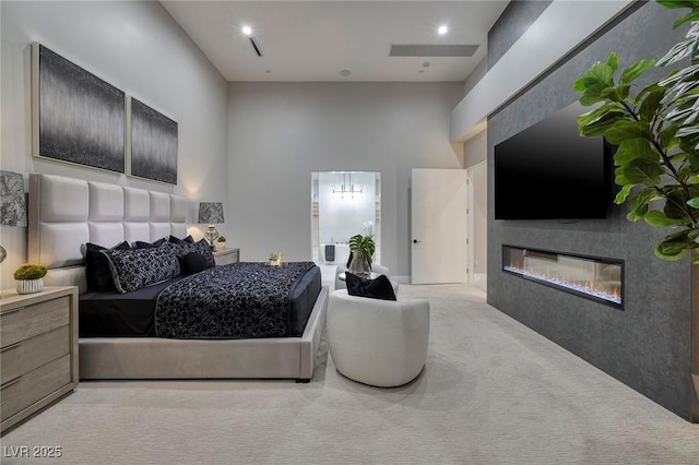 bedroom featuring a towering ceiling and light colored carpet