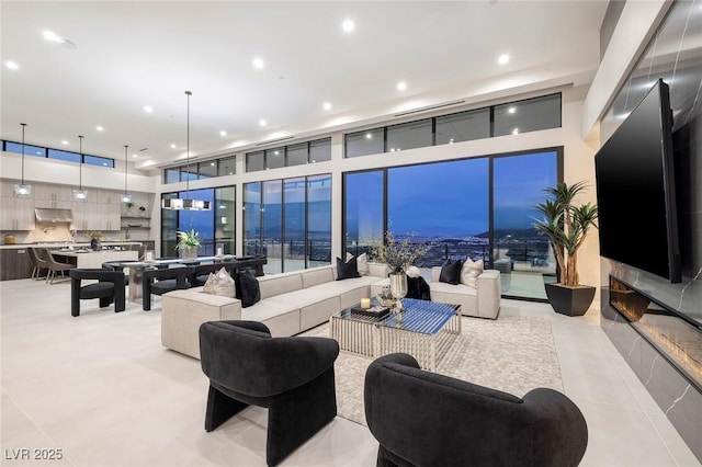 living room with floor to ceiling windows and a high ceiling