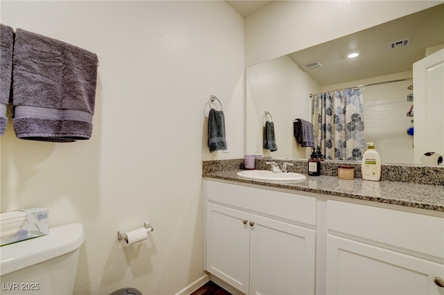 bathroom featuring toilet, vanity, and a shower with shower curtain