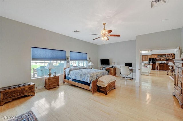 bedroom with multiple windows, ceiling fan, and light wood-type flooring