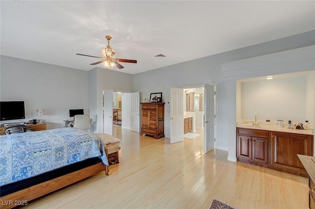 bedroom featuring sink, ensuite bath, and light hardwood / wood-style floors