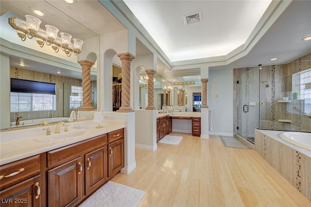 bathroom with vanity, wood-type flooring, plus walk in shower, a healthy amount of sunlight, and ornate columns