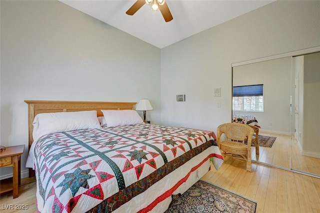 bedroom with ceiling fan, light hardwood / wood-style floors, and vaulted ceiling